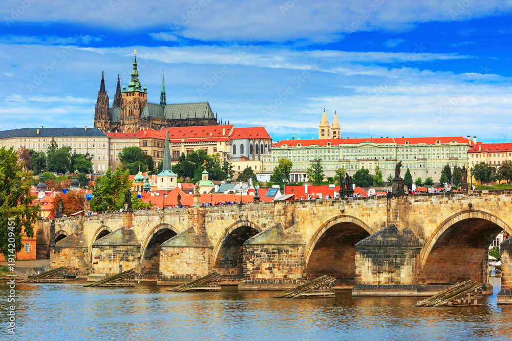 Obraz premium Charles Bridge (Karlův most) in Prague, Czech Republic, spanning the Vltava River with historic towers and Gothic architecture. Panoramic view of the medieval bridge and city skyline, iconic European