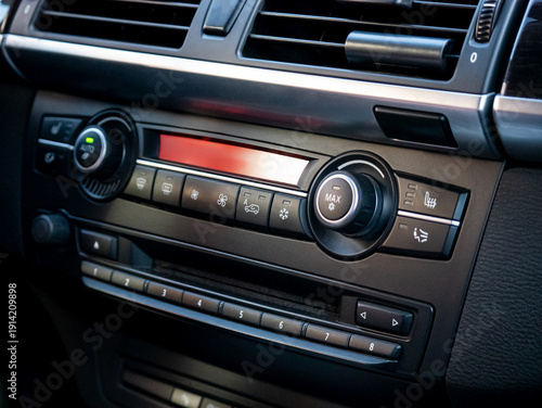 Close up of an automotive dashboard showing climate control and radio navigation system in a new modern car for transportation design