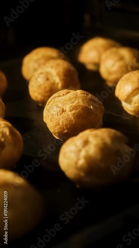 Process of profiterole production. Baking concept. Homemade food. Traditional French profiteroles baking in oven. Timelapse. Baking choux pastries in oven. Vertical video. Close-up in 4K, UHD