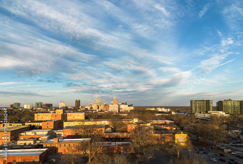 View of old buildings on the Dix Park campus with the Raleigh skyline in the distance