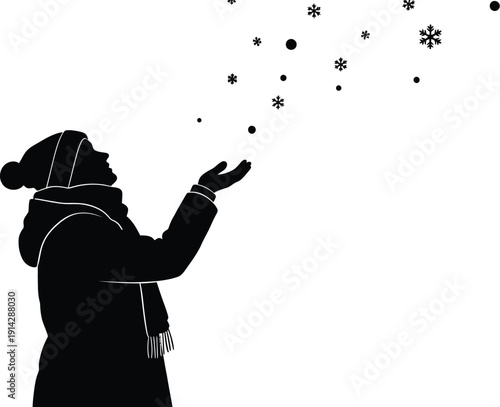 Silhouetted woman in winter attire catches snowflakes with an outstretched hand