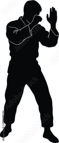 Man in a fighting stance with martial arts uniform and defensive posture