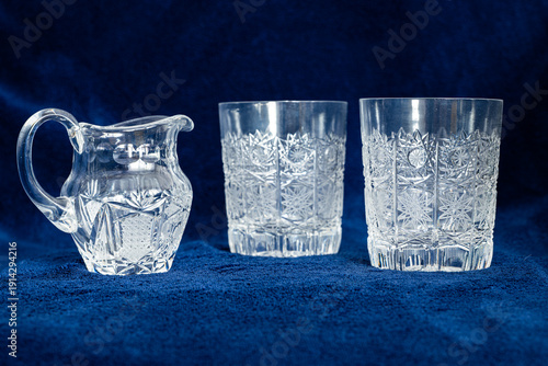 Canvastavla Cut crystal jug and two cut crystal glasses on dark blue textile background