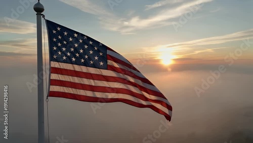 A waving banner representing a specific American territory's emblem, made from woven material, flying atop a pole during the early morning hours amidst atmospheric conditions