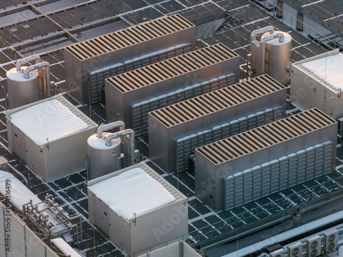 Aerial view of data center cooling and ventilation infrastructure on a snowy rooftop, ensuring optimal server performance, Warszawa, Wojewodztwo Mazowieckie, Poland.