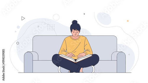 Young woman reading a book on a sofa, cross-legged, enjoying leisure time and knowledge