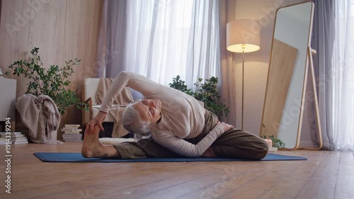 Senior woman reaches extended foot in seated side stretch