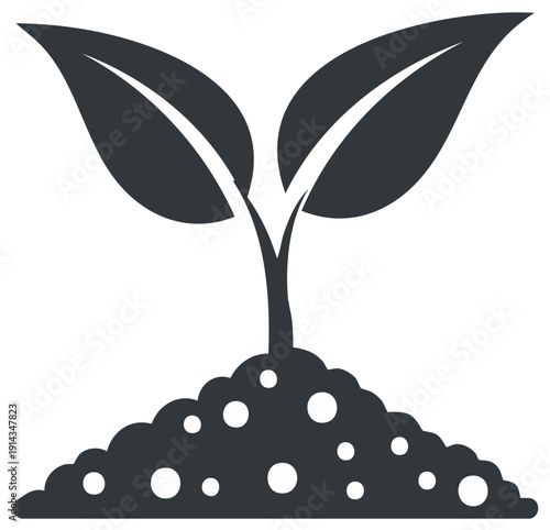 Dark silhouette of a young plant growing from soil with two fresh green leaves and a stalk