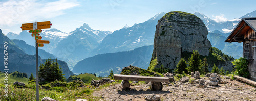 Hiking signs at the Schynige Platte, iconic mountains Eiger and Moench in the background