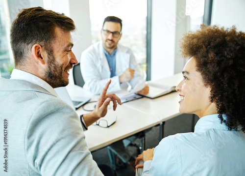 Wallpaper Mural Young doctor and young couple talking in office in the clinic or hospital. Marriage and relationship problems or fertility or pregnancy concept Torontodigital.ca