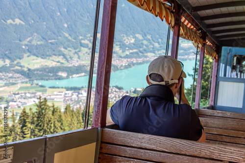 Wallpaper Mural Schynige Platte, Switzerland - August 13, 2025 - A tourist sitting in an empty wagon of the Schynige Platte railway enjoying the view Torontodigital.ca