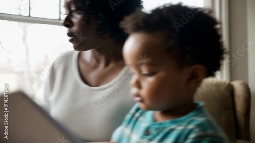 African american grandmother reading a book to grandson