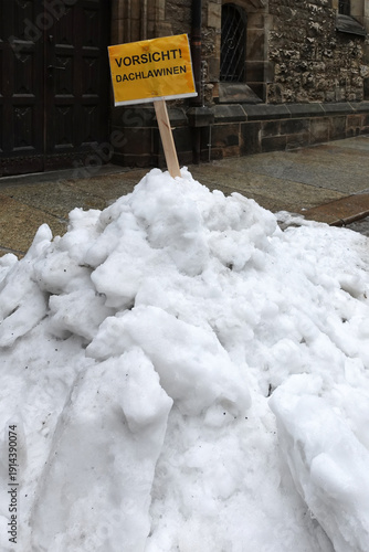 Warning sign for falling roof snow in front of St. Nicholas Church in Leipzig, Germany. 