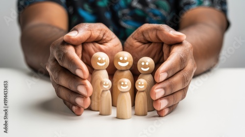 Caring hands protecting a diverse group of small wooden figures with happy smiling faces, symbolizing family, community, support, and emotional well-being.