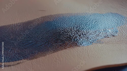 Wallpaper Mural Hand applying dark dye to a piece of leather, creating a smooth, even layer across the surface, showcasing the transformation of the material in a crafting process Torontodigital.ca