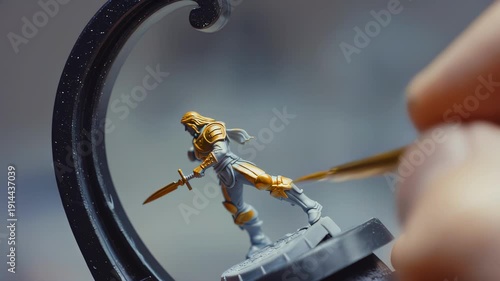 Wallpaper Mural Male miniature painter carefully applies gold paint to a detailed figurine of a knight holding a sword, showcasing intricate craftsmanship in a well-lit workspace Torontodigital.ca