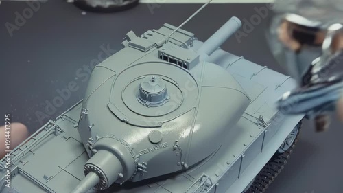 Wallpaper Mural Model tank assembly process showing detailed airbrushing technique on turret and barrel, highlighting precision work in a well-lit workshop environment Torontodigital.ca