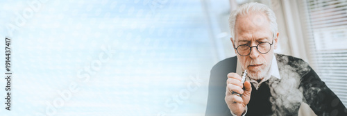 Canvas Print Senior man smoking electronic cigarette; panoramic banner