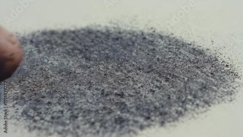 Wallpaper Mural Close-up of a hand smudging black charcoal powder on white paper, creating a textured surface with gradual blending and softening of the material in a creative workspace Torontodigital.ca