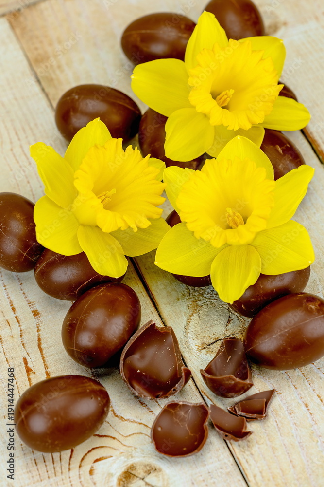 Fototapeta premium Uova di Pasqua di cioccolato con fiori di narciso