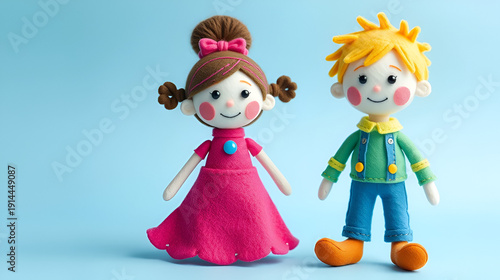 Cute handmade felt dolls boy and girl in colorful outfits with a blue background