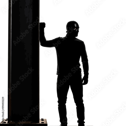 Silhouette of a strong man leaning against an industrial pillar in a dark, contemplative setting