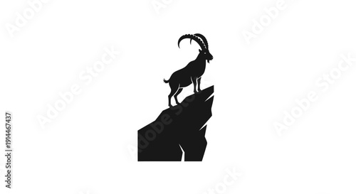 Silhouette of a majestic mountain goat standing on rocky ledge