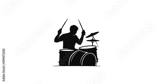Silhouette of a Male Drummer Playing with Drumsticks and Drum Set