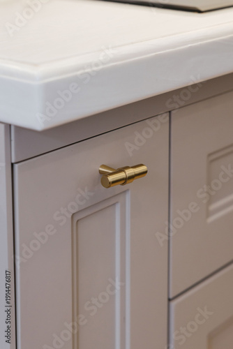 Modern luxury kitchen interior with beige cabinets and navy blue island.