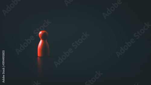Red wooden figure standing alone in dark background with dramatic lighting symbolizing isolation leadership risk and mental health concept with copy space