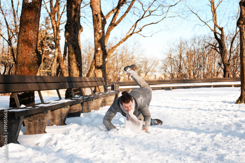 Canvastavla Man slipping and falling on snow in a winter park