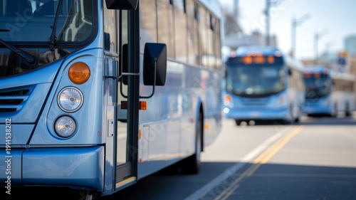 Blue city bus with open door on a street, with other buses blurred in the background.