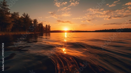Witness the intense tranquility of a wilderness sunset as golden light dances across the water's edge.