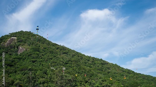 Timelapse of cable cars ascending a lush green mountain in Balneário Camboriú, Brazil