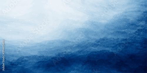 A calm summer day features a beautiful view of white clouds in the blue sky over a peaceful blue ocean horizon with gentle sea waves