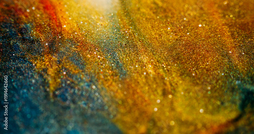 Blur sparkling texture. Colorful particles. Yellow orange blue shimmering stream. Glowing shiny abstract background ink powder flow.