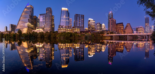 Austin at Dusk - A panoramic dusk view of glittering modern skyscrapers reflecting in calm Lady Bird Lake at Downtown Austin, Texas, USA.