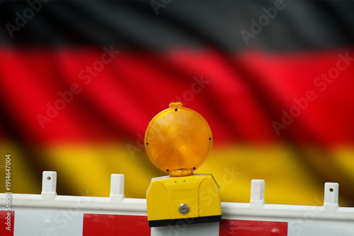 Photos Flagge von Deutschland und Baustellenabsperrung als Symbol für den Umbau, Reform