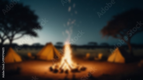 Wallpaper Mural Blurred background of Safari campsite with glowing campfire, realistic sparks flying upward and tent fabric texture visible, open savannah with animal silhouettes in distance, nighttime, warm. Torontodigital.ca