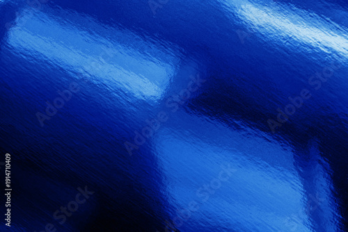 A vivid blue abstract close-up showing a glossy, textured surface reflecting bright cyan light. Flowing ripples create a contemporary look suitable for design, backgrounds, and visual storytelling.