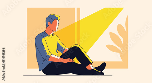 Man sitting on floor reading a book with a yellow light shining on him from a window