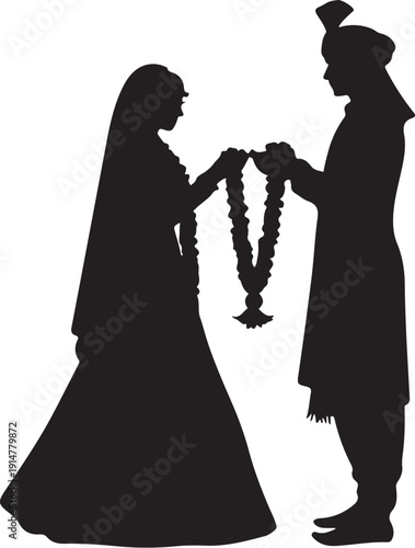 Silhouette of couple exchanging garlands during wedding ceremony