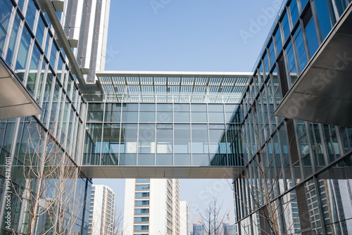 Photos Modern glass skybridge connecting two office buildings in an urban business dist