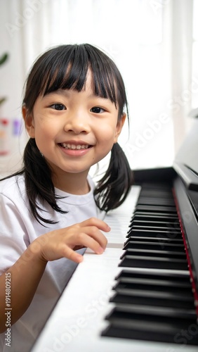 Smiling young girl with pigtails plays piano against blurred window background