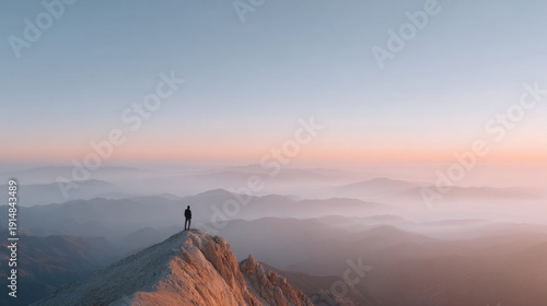 Hiker overlooking sunset on mountain peak.