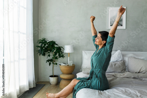 Tableau sur toile Side view of awake mature woman with closed eyes in blue soft cotton bathrobe st
