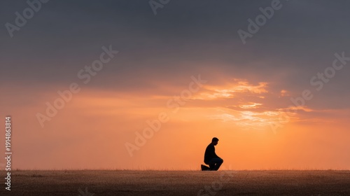 Christian prayer. Man on his knees praying on sunset