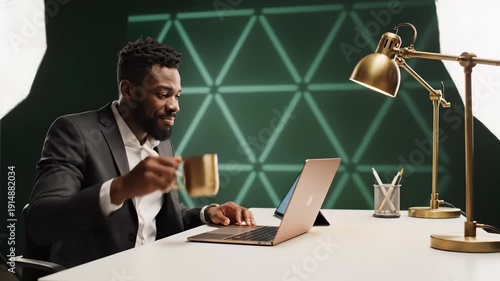 Wallpaper Mural Businessman Working at Desk With Laptop, Drinking Coffee, and Smiling Torontodigital.ca