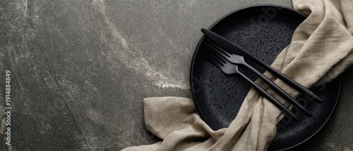 The Black Plate with Matte Cutlery and Linen on Dark Stone Surface