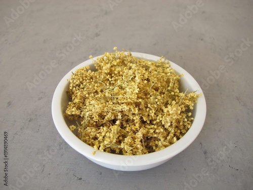 Tableau sur toile Dried elderflowers in a porcelain bowl for herbal tea - natural herbal remedy an